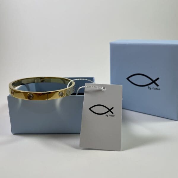 A blue box with a gold fish bracelet in it