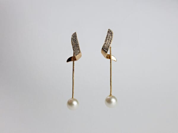 A pair of earrings with pearls and gold