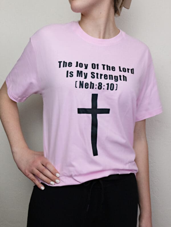 A woman wearing a pink shirt with a cross on it.