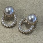 A pair of earrings with pearls and gold beads.