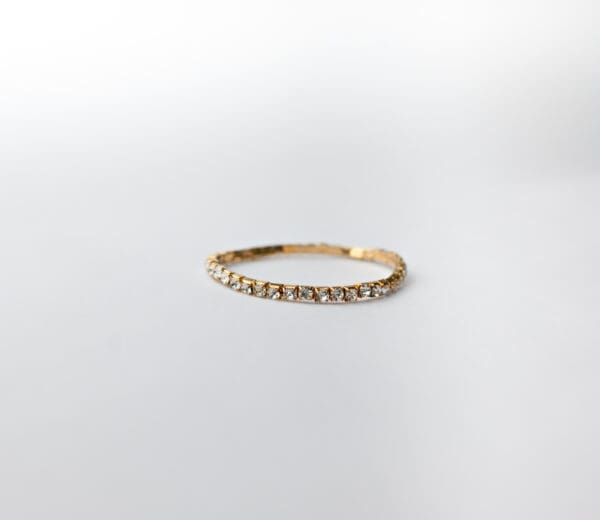 A gold ring with some white stones on it